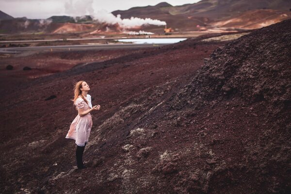 Fille grimpe sur la montagne en robe