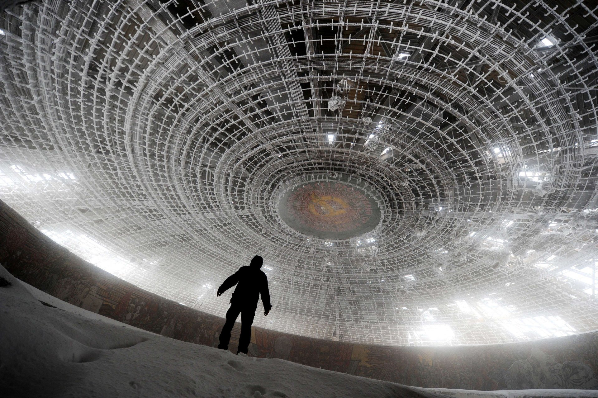 abandoned monument to communism bulgaria man black soviet union light snow roof