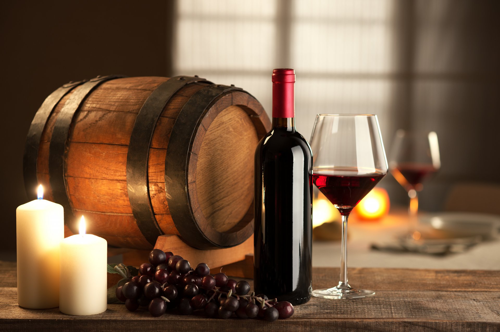 barrel candles grapes a bottle glass wine red