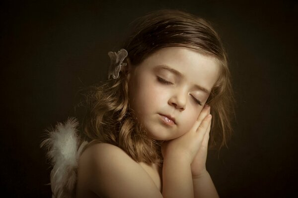 Kleines Mädchen, Engelchen, schläft mit den Händen unter dem Kopf