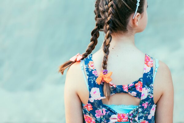 La schiena di una ragazza con belle trecce