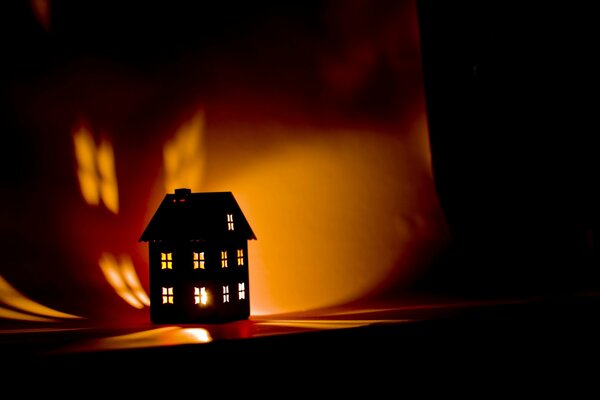 Dom zapala się w ciemności ze świecą w środku