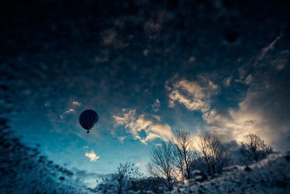 Ballon dans les nuages bleus au-dessus de la petite forêt