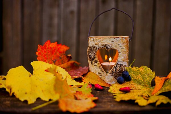 Composition of a natural candlestick with a candle and yellow leaves