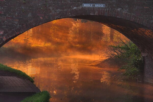 Image of a bridge over a river at sunset