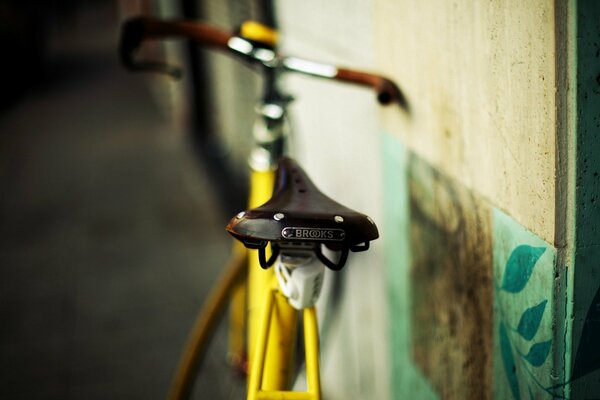 Yellow bicycle leaning against the wall