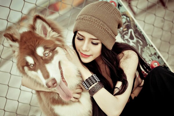 Mädchen in einer Mütze mit einem Husky-Hund