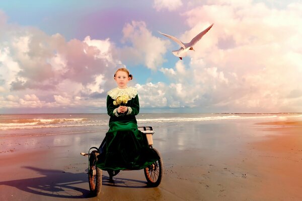 A girl in a green dress on the seashore