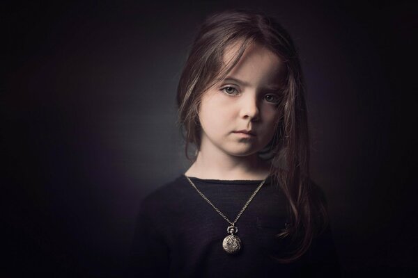 Portrait of a girl in black with a large pendant