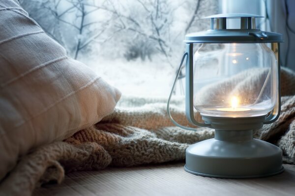 Lampe au kérosène, plaid et oreiller sur le rebord de la fenêtre sur le fond de l hiver à l extérieur de la fenêtre