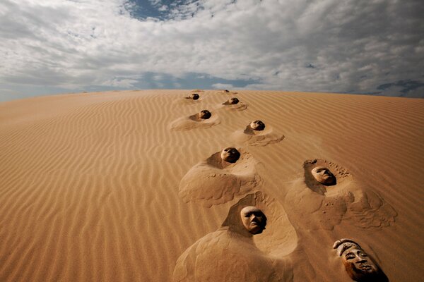 Masks of people spread out in the desert