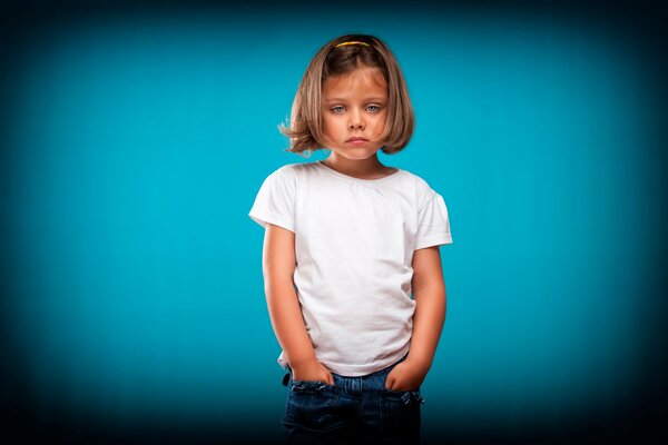 Retrato de una niña mirando sobre un fondo azul