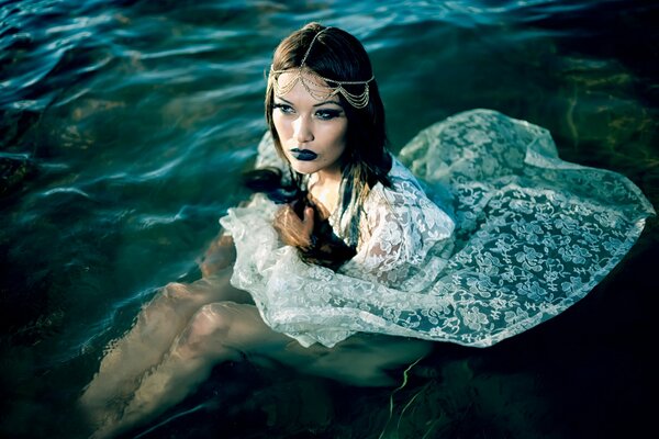 Chica en el agua en un vestido blanco