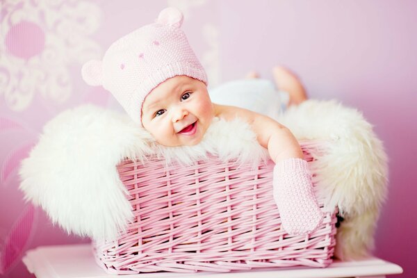 Bébé souriant dans un panier rose