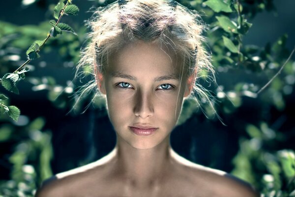 Retrato de una hermosa niña en el fondo del follaje