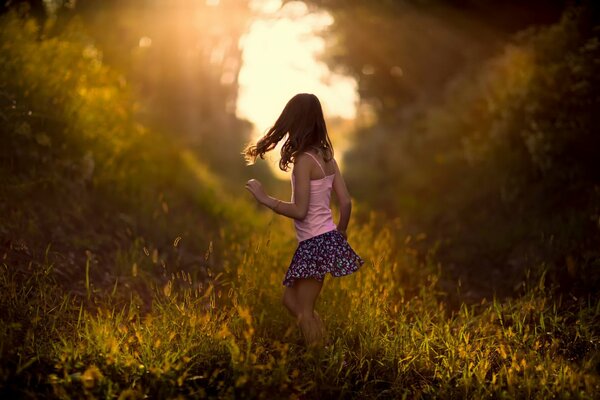 Natura mattutina, dipinta con colori vivaci e illuminata dai raggi luminosi del sole. Bambina che corre alla luce