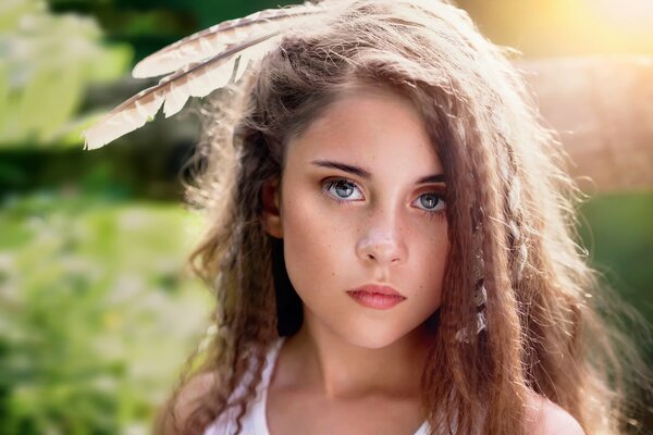 A girl with feathers on her head and curly hair