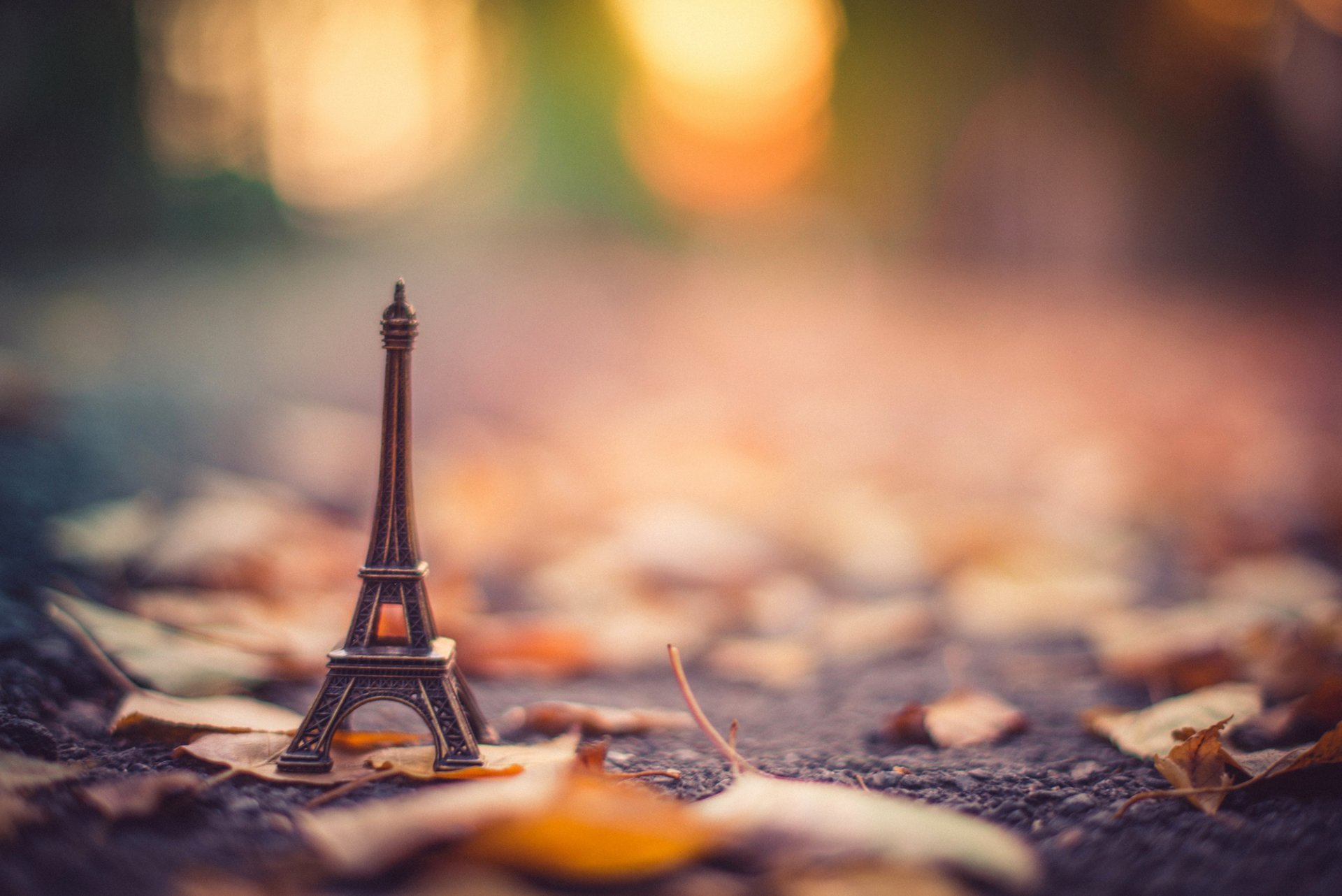 statuetta stand la tour eiffel torre eiffel asfalto foglie secco autunno bokeh sfocatura