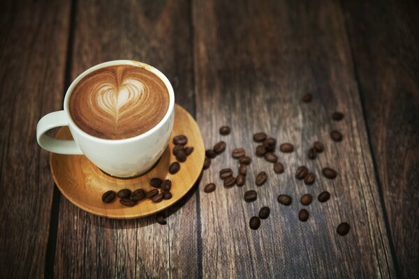 Sur la table se trouve un café avec un motif de coeur