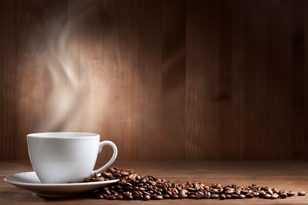 Taza blanca y platillo con granos de café desmenuzados