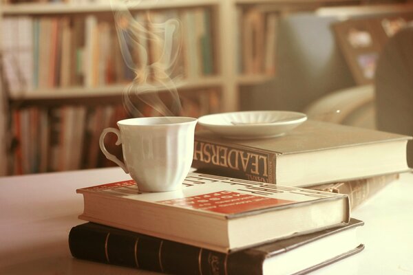 Hot tea with books on the table light photo