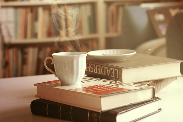Gorąca herbata z książkami na stole jasne zdjęcie