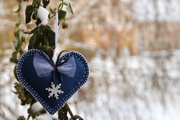 Cuore blu con fiocco di neve su sfondo invernale