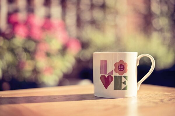 На столе стоит чашка про любовь