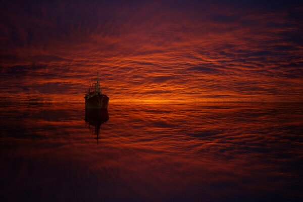The ship and the clouds in the reflection at sunset