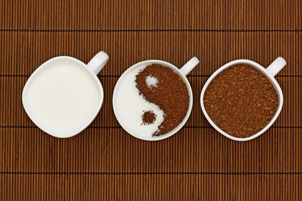 Tres tazas de café y leche representan el símbolo Ying-Yang