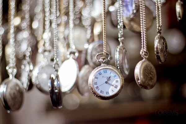 Beautiful watches on chains hanging next to each other