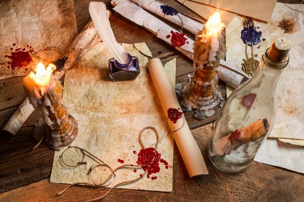 Letters on parchment, next to an inkwell and a bottle with a note inside