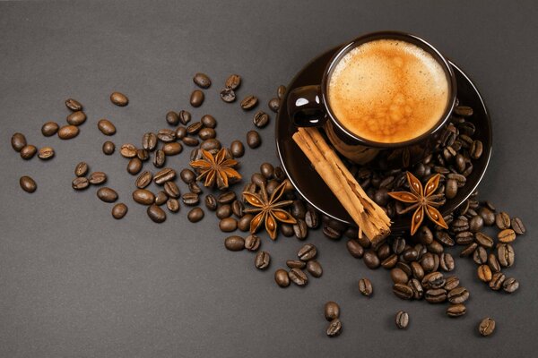 Grains de café et cannelle à côté d une tasse de café