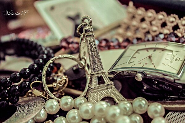 Eiffel Tower keychain next to chain jewelry and watches