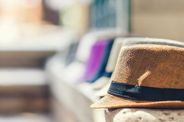 Sombrero de lona sobre el fondo borroso de la calle y otros sombreros