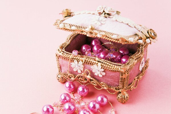Boîte à bijoux avec des perles roses sur des fils