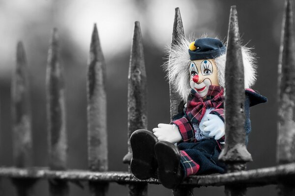 Sad clown on the fence alone