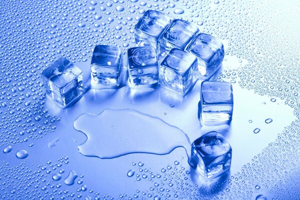Cubitos de hielo sobre fondo azul con gotas