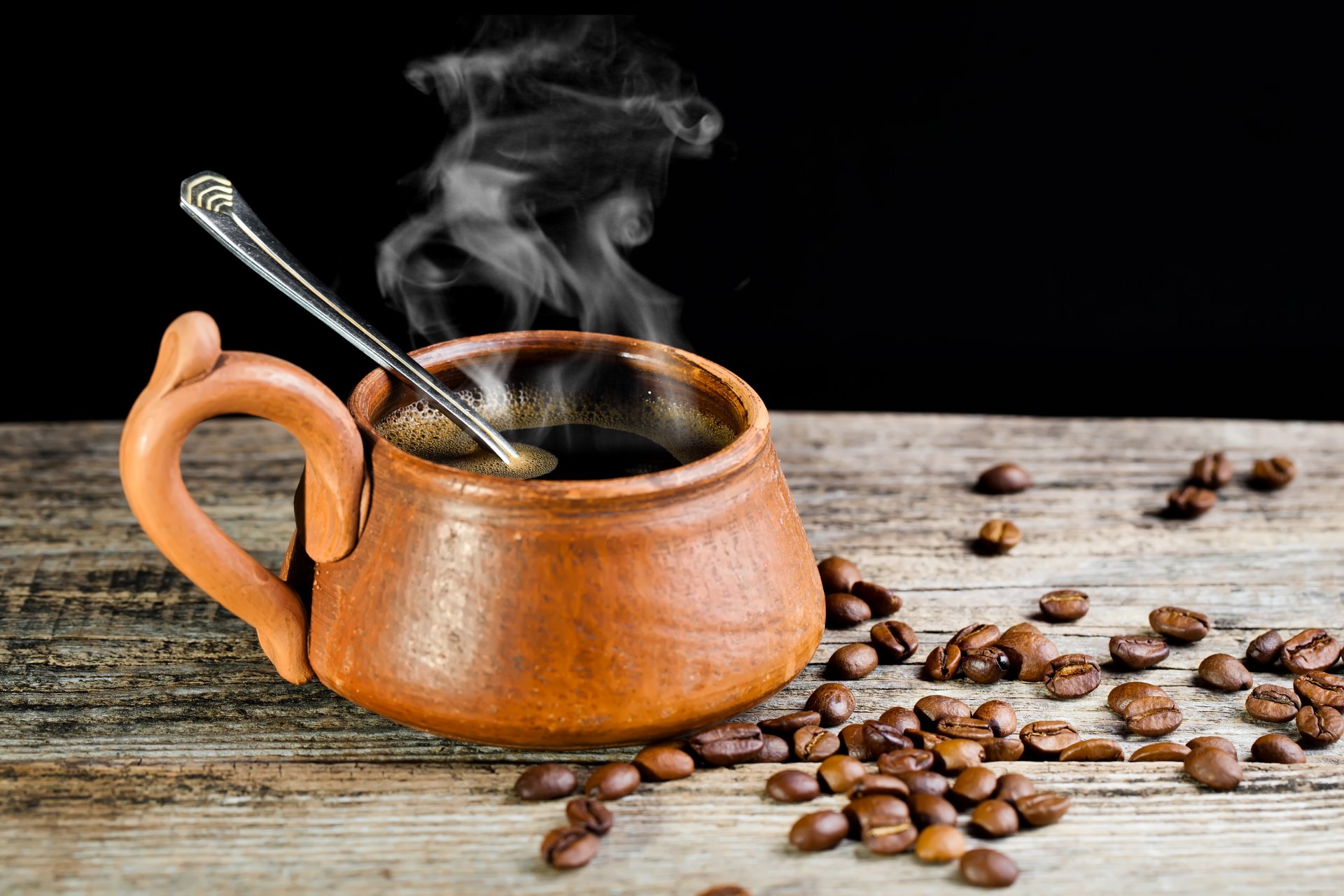 kaffee löffel tasse dampf getreide tisch holz schwarzer hintergrund