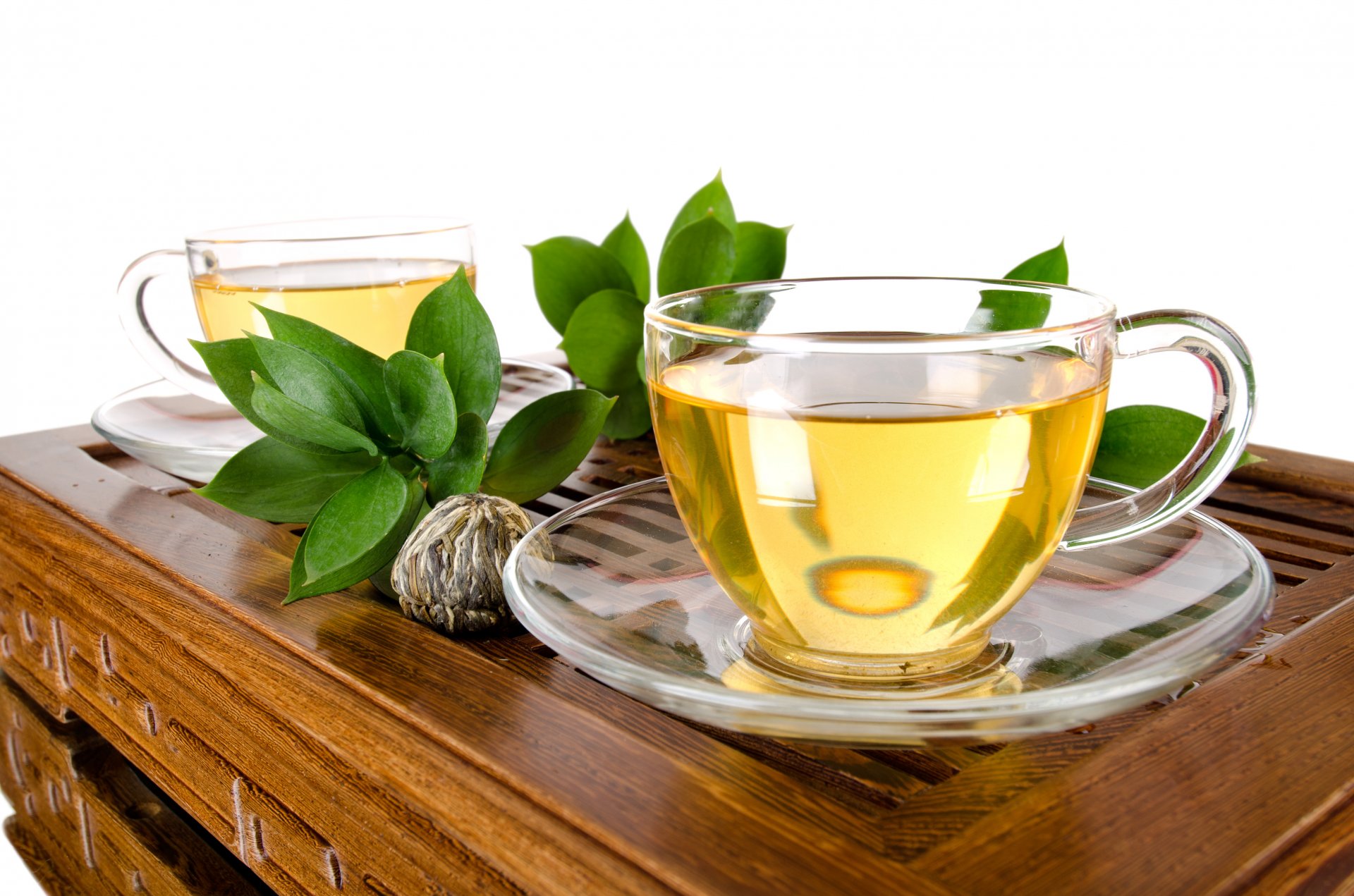 green tea drink cups leaves table white background