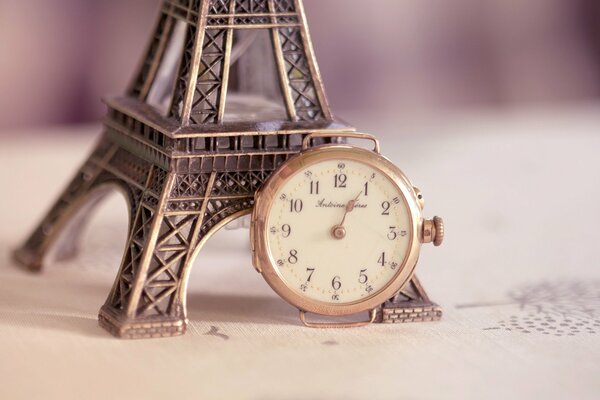 A statuette of the Eiffel Tower stands next to the clock
