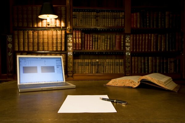 A picture on the table of a computer with a book on the background of a library