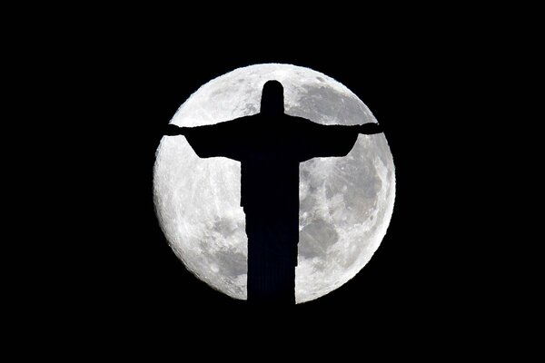 Статуя христа спасителя в бразилии вночи на фоне полной луны