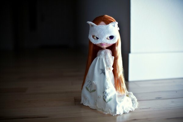 A little red-haired doll in a cat mask