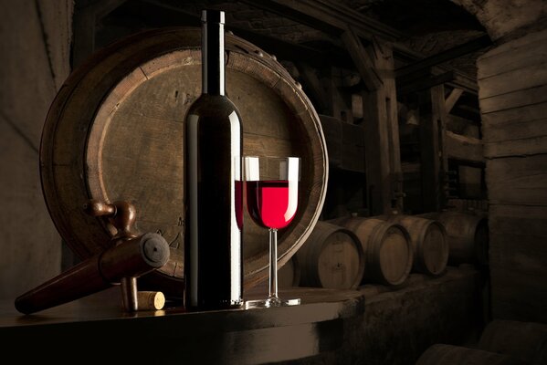 A glass of wine against the background of barrels in the wine cellar