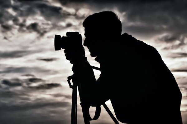 Silhouette di un uomo con una macchina fotografica di notte