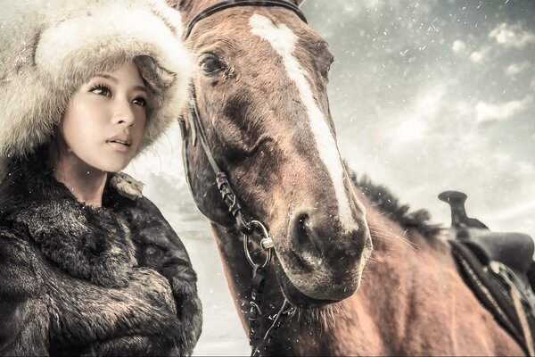 A girl in a fur coat and a hat with a horse