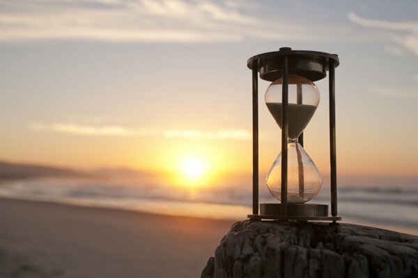 Sanduhr auf Strand Hintergrund mit Meer auf Sonnenuntergang Hintergrund Tapete