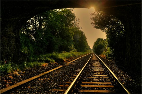 The sun s rays fall into the arch and onto the railway