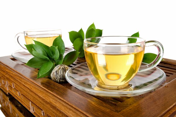 Transparent cups with green tea on a white background